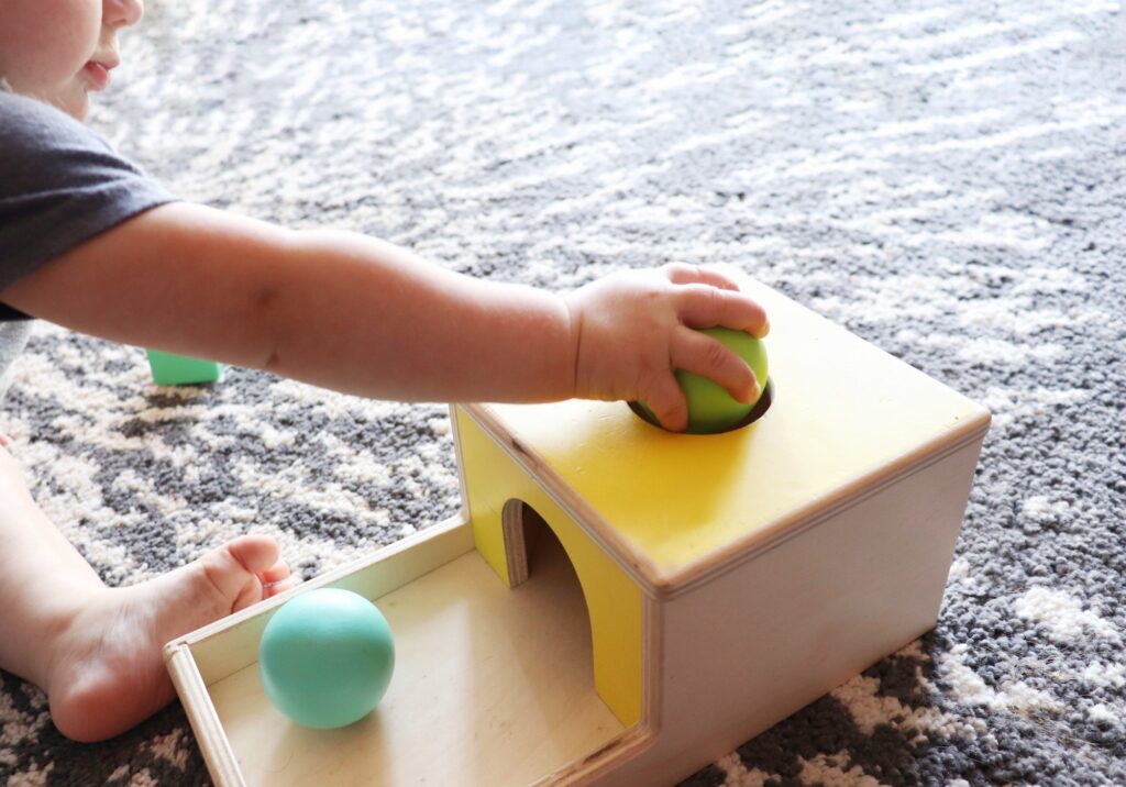 Baby Playing with Toy Ball and Box